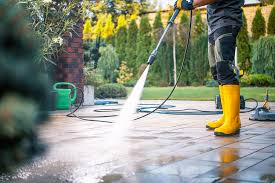 Pressure washer cleaning a concrete driveway revealing fresh clean surface