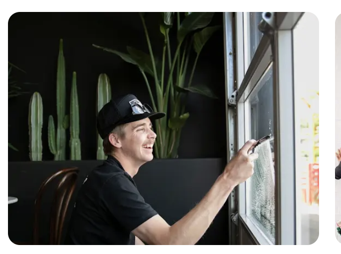 Professional cleaning the exterior of a large home window with a squeegee
